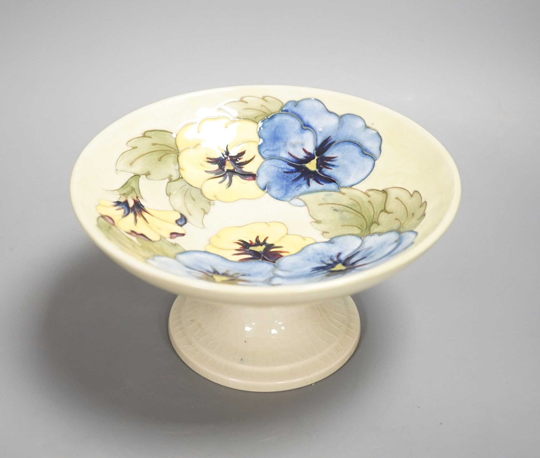 A Moorcroft pansy designed, yellow ground comport, stickered and sighed to underside, with box,9 cms high.
